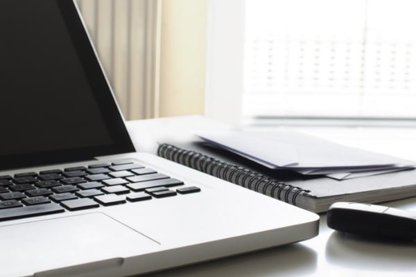 Close up image of laptop and notepads