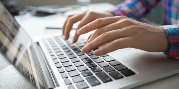 Cropped image of hands typing on laptop